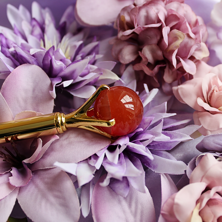 Carnelian pen lying on a bed of flowers