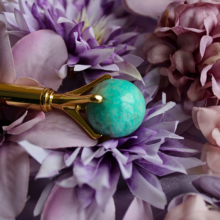 Blue Amazonite pen lying on a bed of purple flowers
