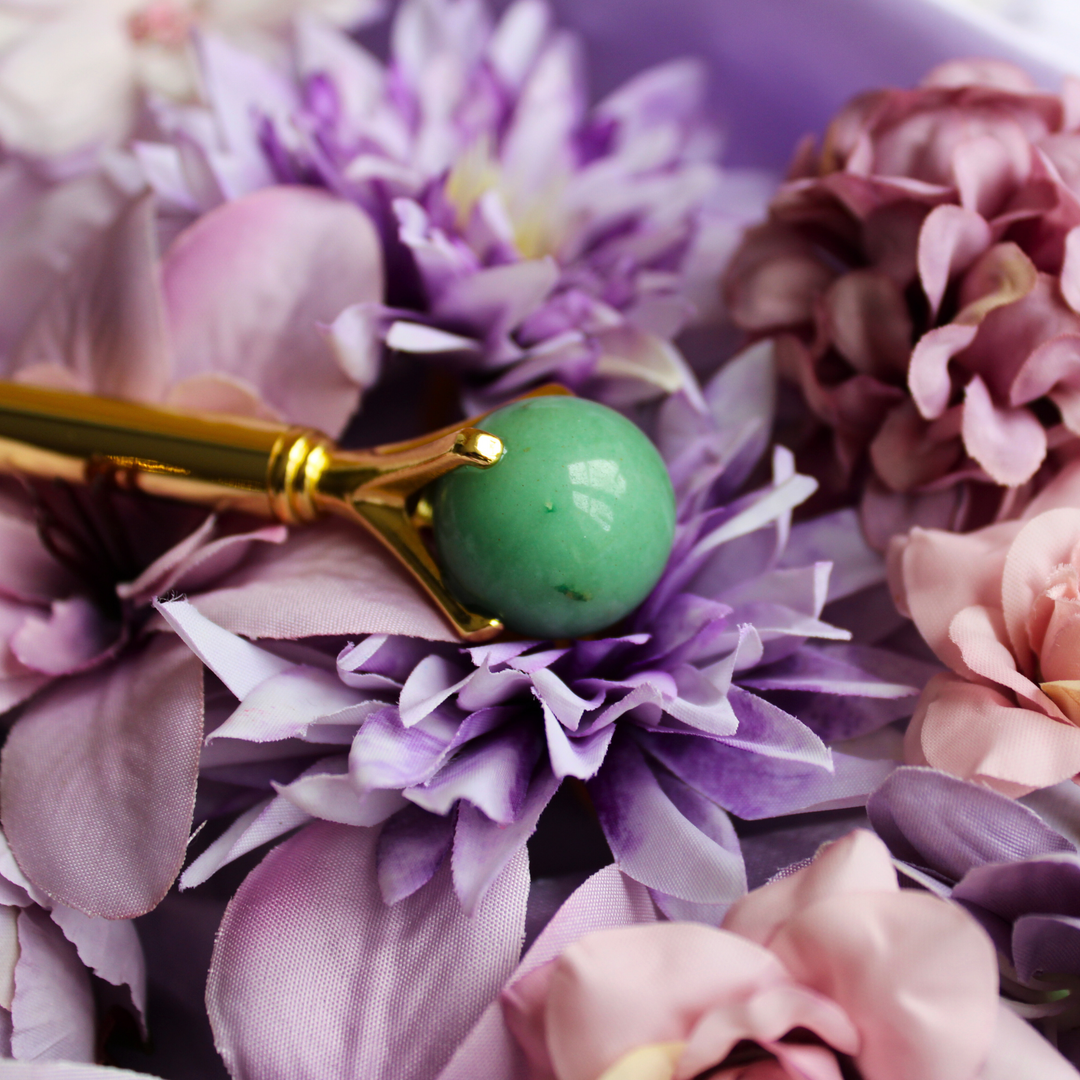 Green Aventurine pen lying on a bed of flowers