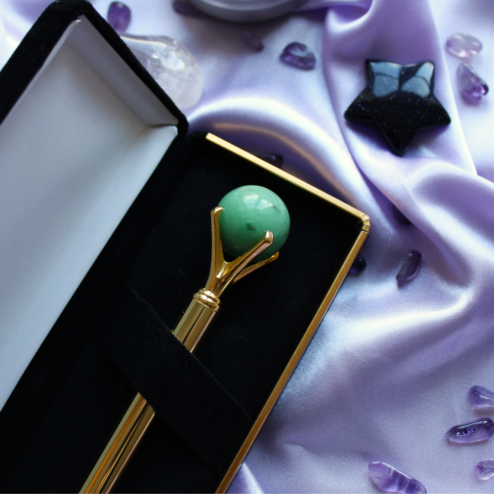 Gold crystal pen surrounded by crystals for luck and prosperity