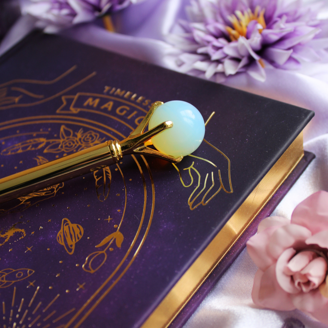 Opal pen on top of a mystical manifesting journal