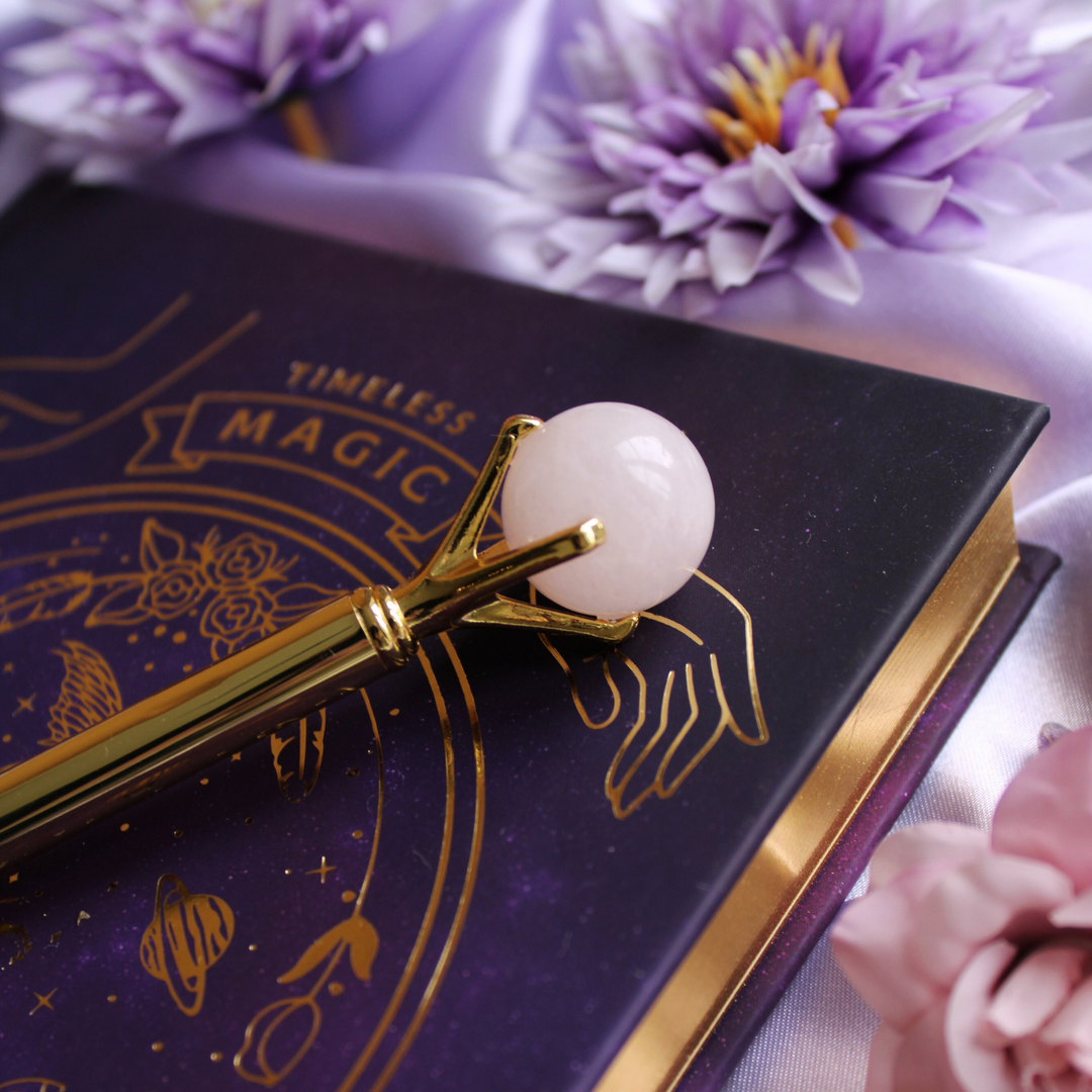 Rose Quartz pen on top of a manifestation journal