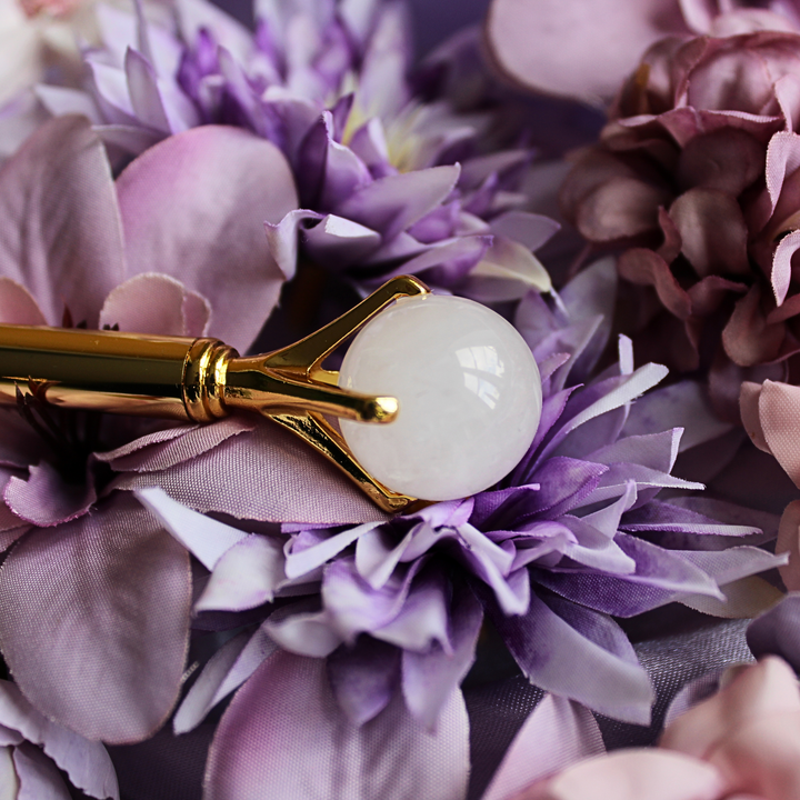 Clear Quartz pen lying on a bed of purple flowers