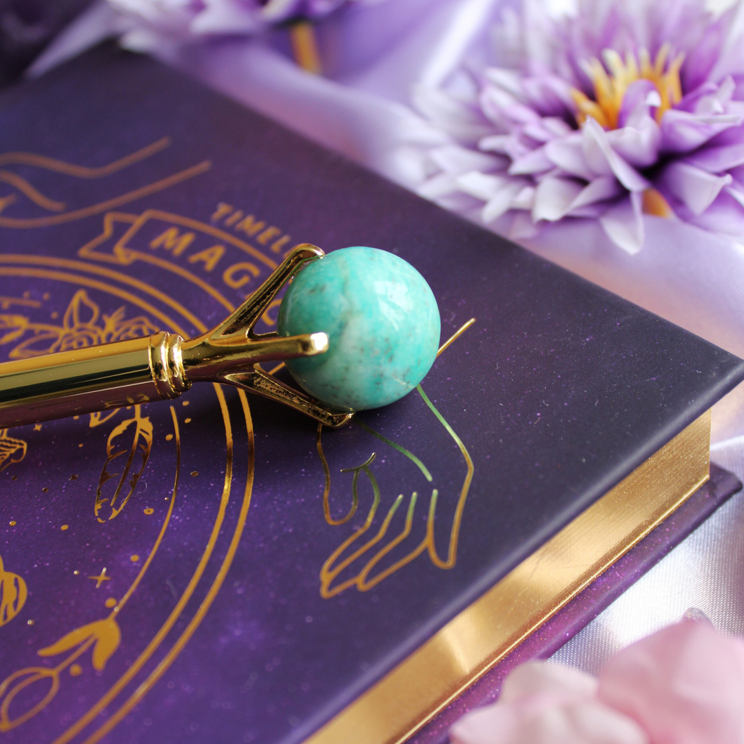 Amazonite pen on top of a gold celestial manifesting journal