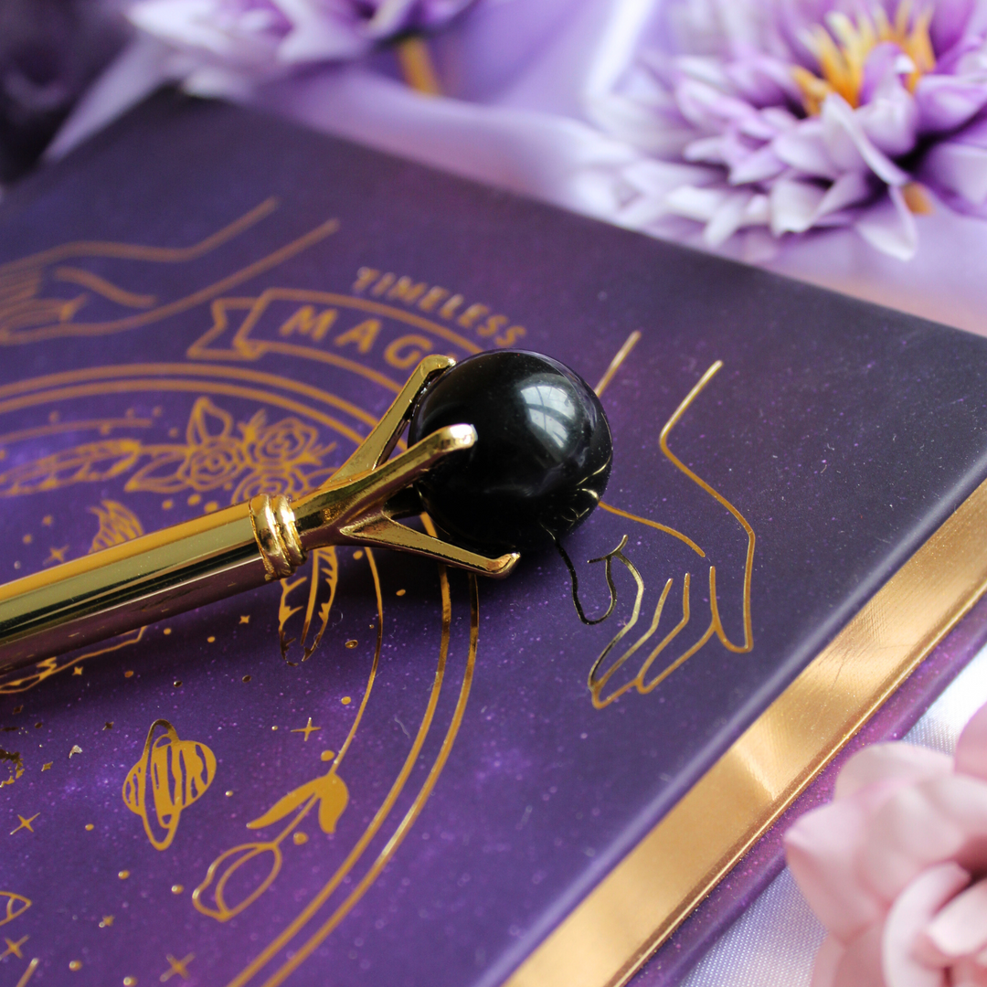 Black obsidian pen on top of a manifestation journal