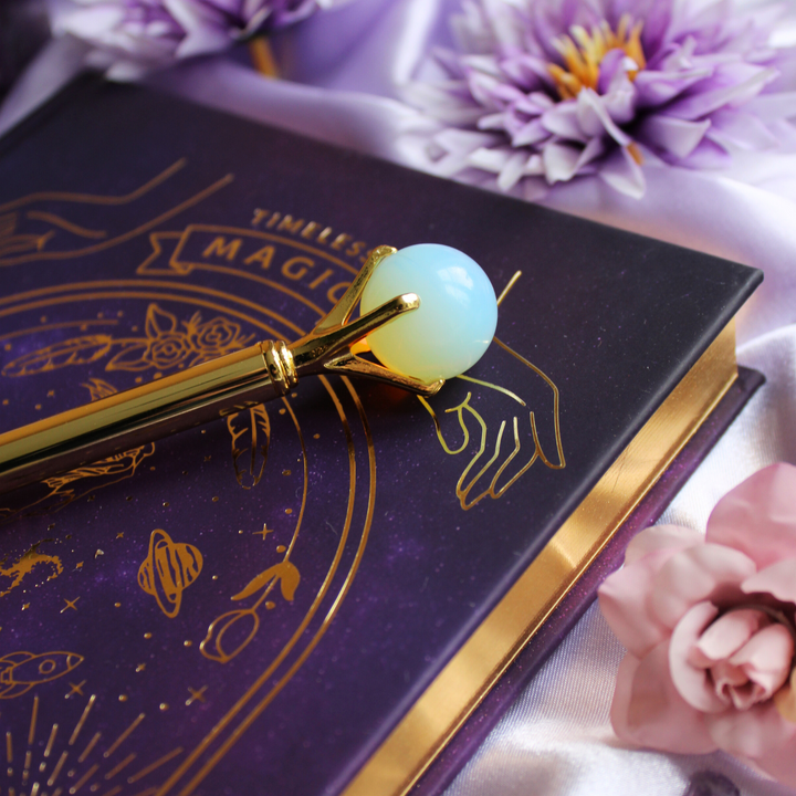 Opal pen on top of a mystical manifesting journal