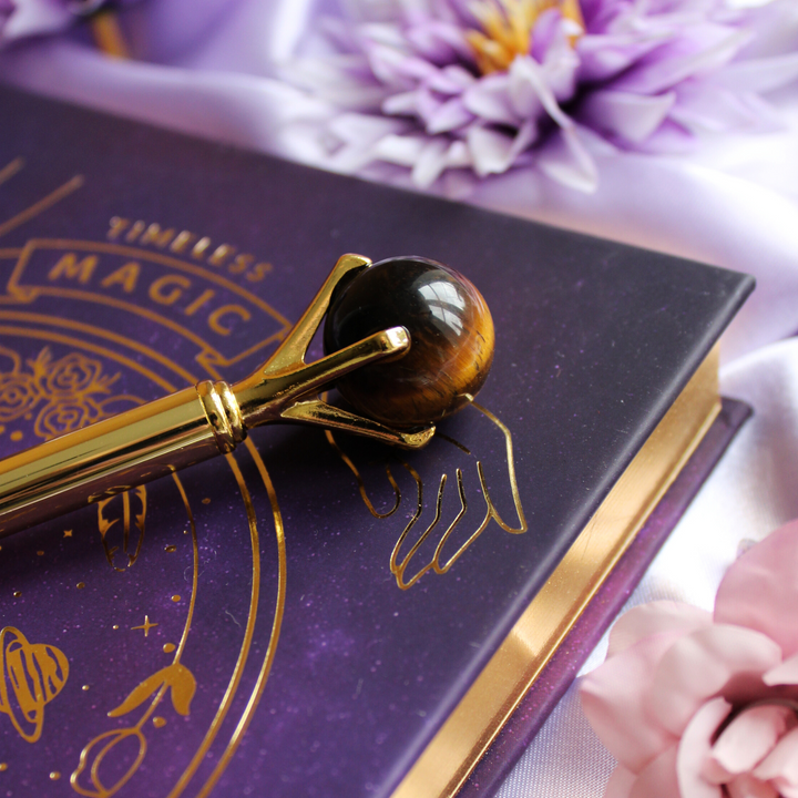 Tigers Eye pen on top of a purple celestial manifestation journal