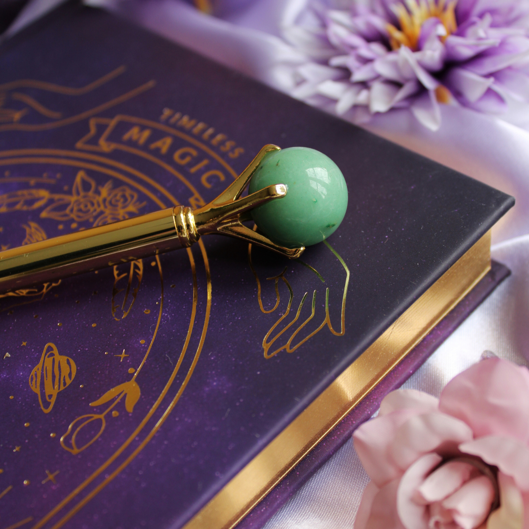 Green Aventurine pen on top of a guided manifestation journal