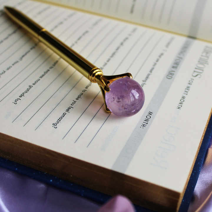 Amethyst pen on top of a daily gratitude journal