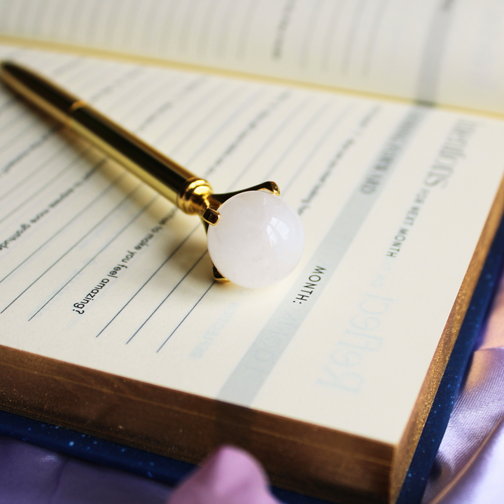 Clear Quartz Crystal ball pen for increased concentration and healing on top of a gratitude journal